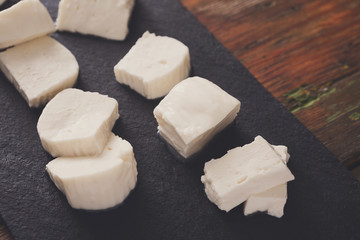 Homemade mozzarella on black stone background