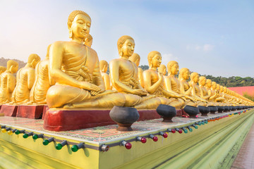 many golden buddha statues sitting in row at public temple nakornnayok  thailand.