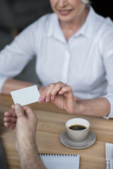 Businessman giving business card to female client