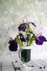 Picturesque bouquet with irises and wildflowers on a wooden table