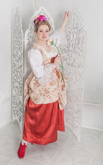 Beautiful woman in medieval dress holding pink rose