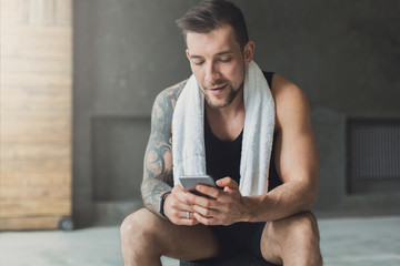 Handsome man use mobile phone in gym