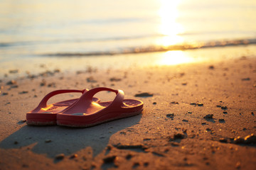 Fototapeta na wymiar Golden dawn over the beach with casual slipper .Rawa island , Malaysia . Selected focus on center .