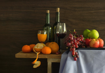 Pile of Fruits and bottle wine with glass put on the plank in bright day / Still Life image and...