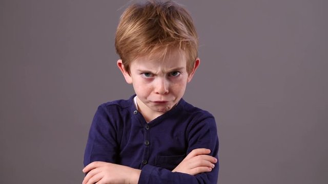 frowning unhappy child with dirty look making a statement