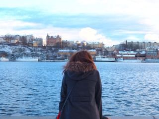 Young woman looking at the sea (baltic), view of city hall in Stockholm, Sweden