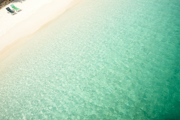Beach tropical with two relaxing chair ,white sandy and crystal water seen from above. Rawa island ,Malaysia .