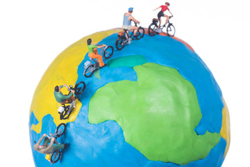 miniature people riding bicycle around the globe isolated on white background © kwanchaift