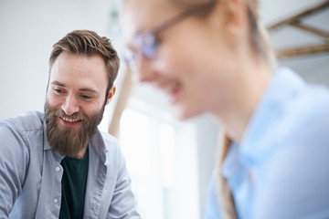 Female and male designers looking down in design studio meeting
