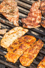 Frying pork and chicken meat on the barbecue grill