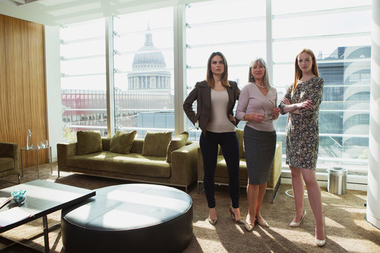 Businesswomen standing by office sofa, London, UK