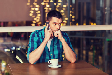 man with smartphone and coffee at restaurant