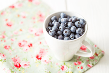 White Bowl Cup with Fresh Ripe Blueberries on Light Wooden Table, Horizontal View