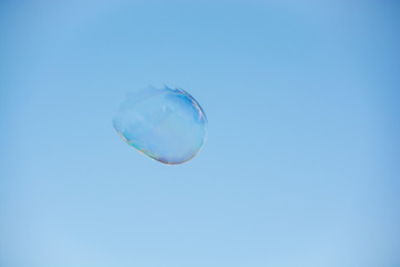 Floating soap bubble bursting