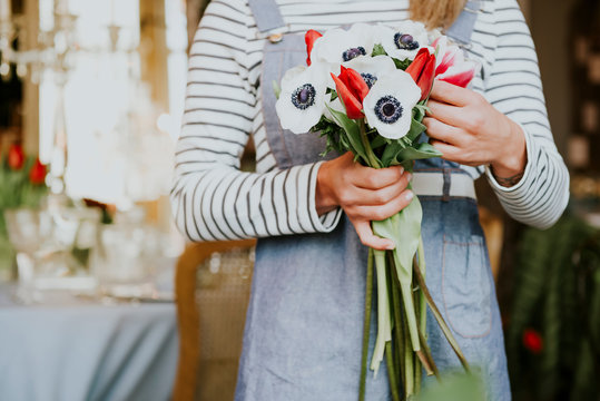 Florist in flower shop, preparing bouquet, mid section