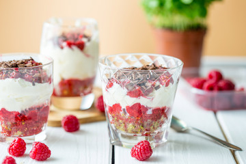 Dessert in Glass with Chocolate, Cream, Raspberry Jam and Pistachio on a Wooden Background, Horizontal View