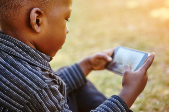 Boy playing game on cellular phone
