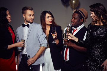 Multi-ethnic group of stylish friends gathered together in order to celebrate New Year