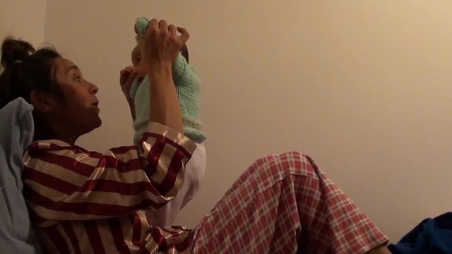 Mother with funny hairdo playing with her baby 