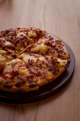 Hawaiian Pizza on wooden table.