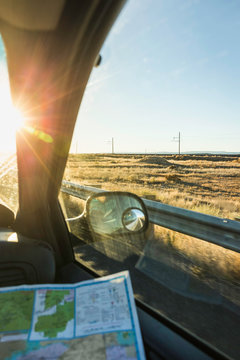 Wing mirror view of man with map on the road in sunlight, Arizona, USA