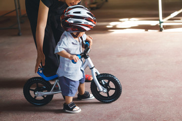 Asian mother teach her son to play baby balance bike