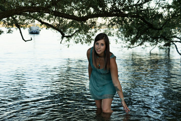 La ragazza in abito elegante nel lago