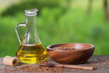 flax seeds and linseed oil in a glass jug on a wooden table