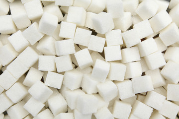 Fototapeta na wymiar Background of pieces of white refined sugar from beet
