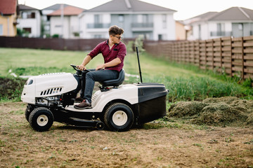 professional worker mowing lawn and cutting grass using powerful mower