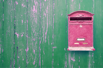 Red mailbox on the green wooden door