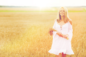 Fototapeta na wymiar happy young woman with spikelets on cereal field
