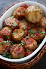 Close-up of sicilian whole baked potato served with chopped parsley and tomato sauce