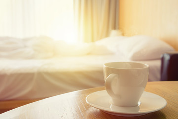 Fototapeta na wymiar coffee cup in bed room vintage warm color tone