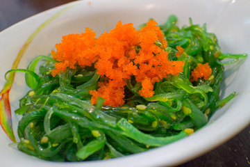 Delicious green seaweed salad with shrimp eggs
