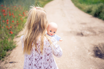 little girl with doll in the street