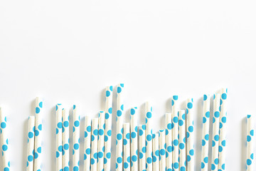 blue polkadot paper straws on white background.