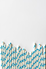 blue polkadot paper straws on white background.