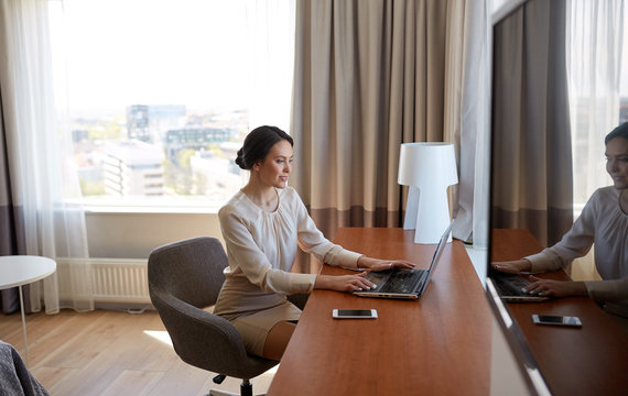 businesswoman typing on laptop at hotel room