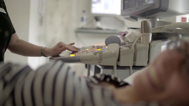 Doctor Using Ultrasound Equipment Screening Of Woman