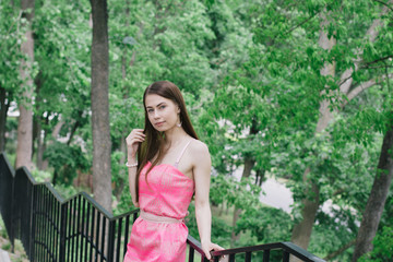Portrait of a beautiful young girl on a clear sunny day. Green trees