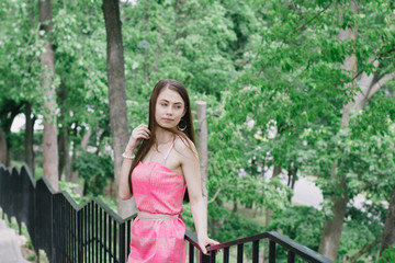 Portrait of a beautiful young girl on a clear sunny day. Green trees