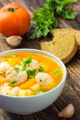 Meatball vegetable soup in a white bowl. 
