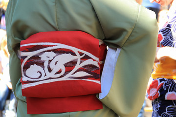 Red color banding sash with white embroidery on green kimono