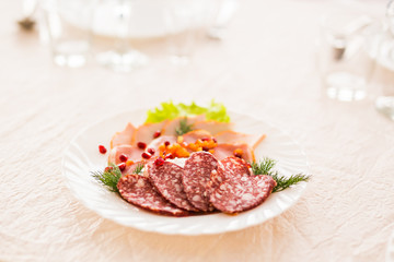 Dish with sliced meat products on the festive table