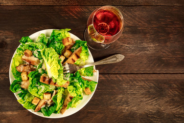 Chicken Caesar salad with wine on rustic texture with copyspace