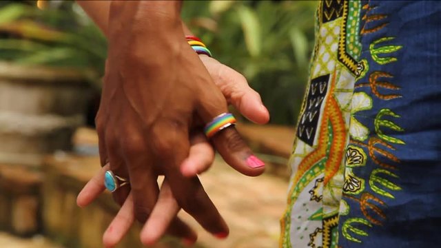 People hold hands outside, close up