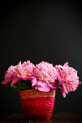 bouquet of pink peonies in a wicker vase