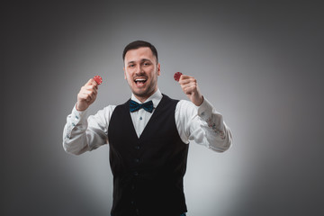 A man holding up red poker chips. Poker