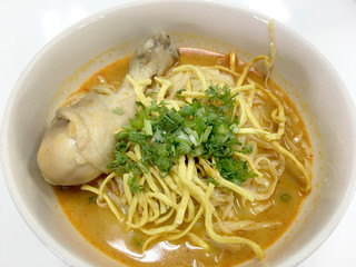 Thai spicy food, Egg noodle in chicken curry in white blow on white background or name in thai is khao soi kai, local cuisine North of Thailand.